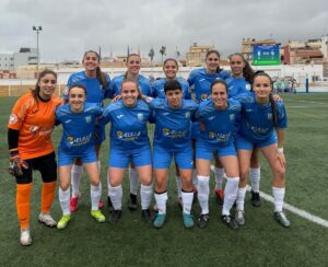 Equipo femenino de fútbol del ATM Melilla posando en el campo.