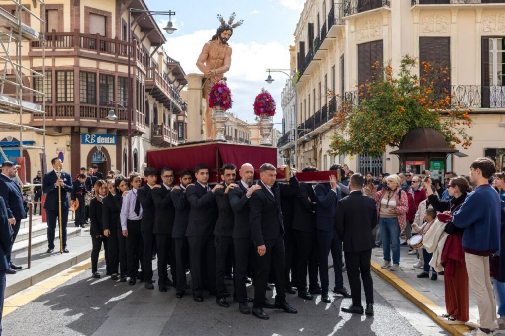 Grupo de personas llevando un paso religioso durante un traslado en Melilla