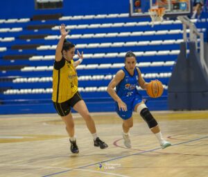 Jugadora del equipo La Salle driblando el balón en un partido de baloncesto