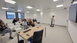 Un presentador en un aula con estudiantes escuchando atentamente