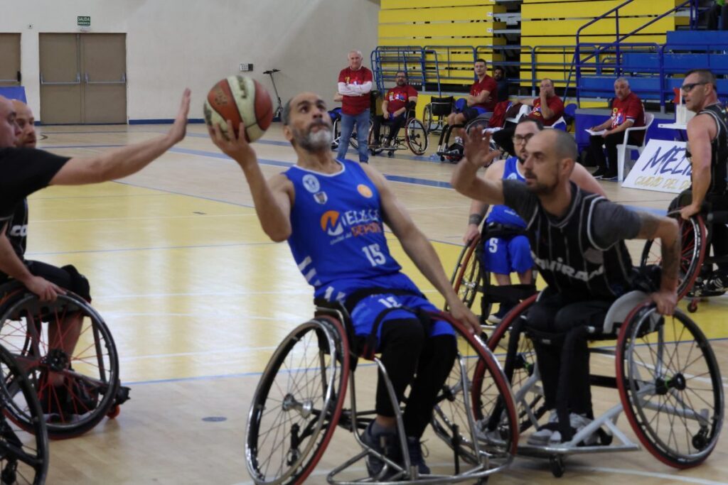 Jugadores de baloncesto en silla de ruedas durante un partido competitivo.