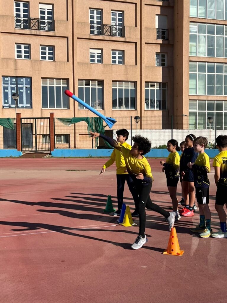 Niños compitiendo en una prueba de atletismo en el Estadio Municipal.