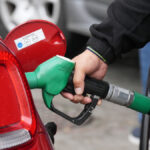 Persona llenando un tanque de gasolina en una gasolinera