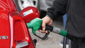 Persona llenando un tanque de gasolina en una gasolinera