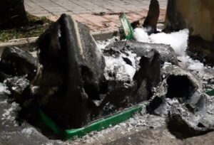 Restos de un contenedor quemado en la calle con nieve