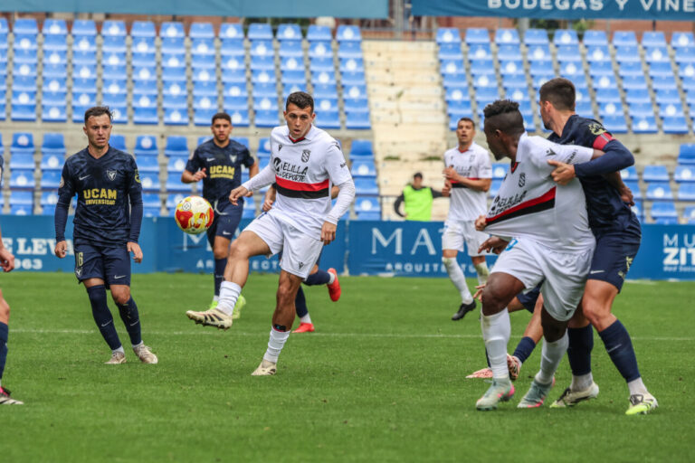 Jugadores de U.D. Melilla y UCAM Murcia en un partido de fútbol