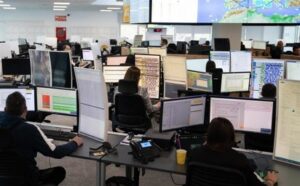 Oficina con varias personas trabajando en computadoras múltiples