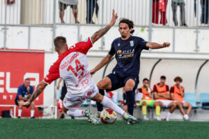 Jugadores de la U.D. Melilla y Club Atlético Antoniano en un partido de fútbol.