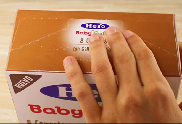 Persona tocando una caja con etiqueta en braille para productos alimenticios.