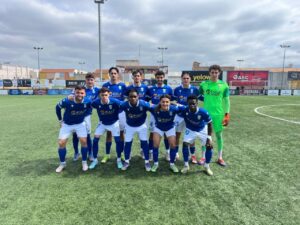 Equipo de fútbol filial de la U.D. Melilla posando en el campo