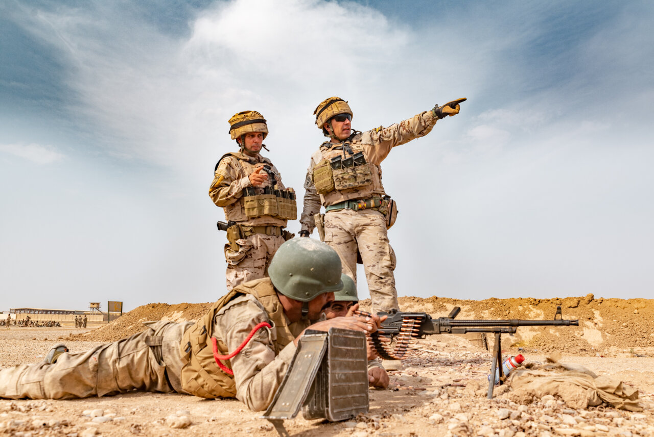 Militares en entrenamiento con armamento en un campo de operaciones.