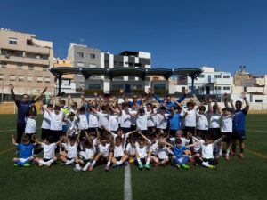 Grupo de niños y entrenadores en un campo de fútbol