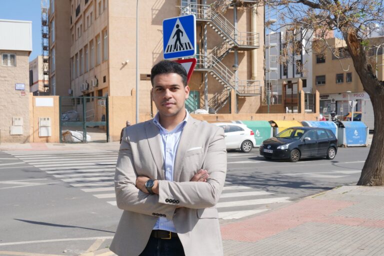 Hombre de pie en una calle con señal de peatones en Melilla.