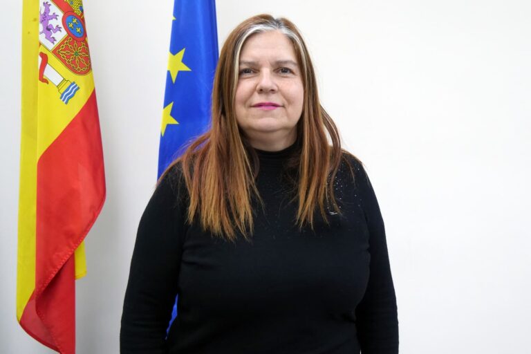 Retrato de una mujer frente a banderas de España y la Unión Europea.