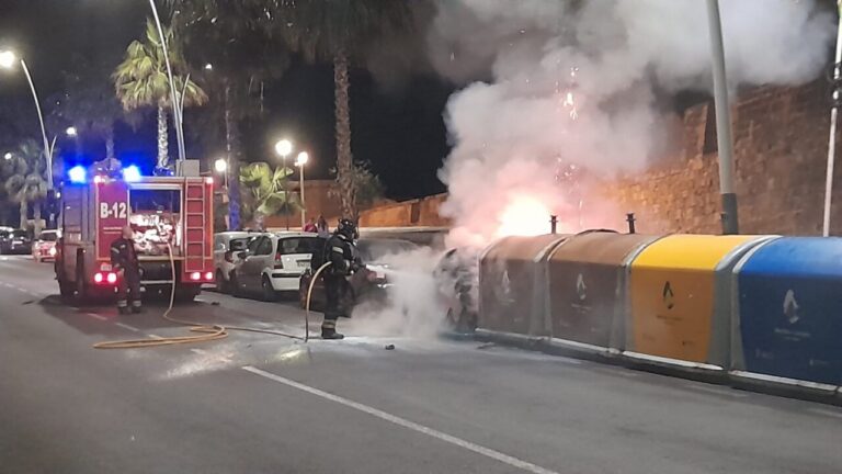 Bomberos extinguiendo un incendio en contenedores de residuos en la ciudad.