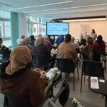 Mujeres participando en jornadas sobre emprendimiento en un salón moderno.
