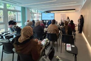 Mujeres participando en jornadas sobre emprendimiento en un salón moderno.
