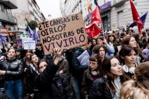 Jóvenes en manifestación sosteniendo pancarta sobre feminismo.