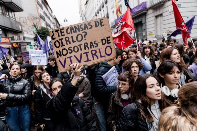 Jóvenes en manifestación sosteniendo pancarta sobre feminismo.
