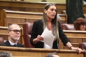 Mujer hablando en el parlamento con documentos en mano