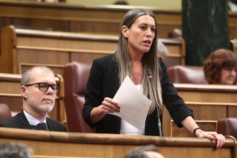 Mujer hablando en el parlamento con documentos en mano