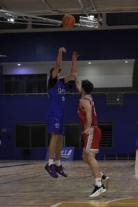 Jugador lanzando un balón de baloncesto durante un partido