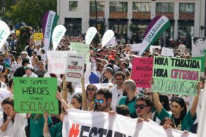 Protesta de médicos en Málaga con carteles sobre condiciones laborales