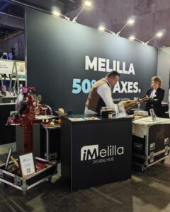 Stand de iMelilla en el Mobile World Congress 2026 con personal interactuando.
