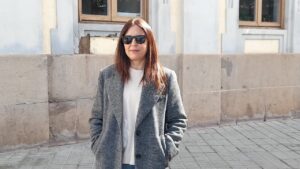 Mujer reflexionando sobre el impacto de la guerra en los precios de la gasolina.