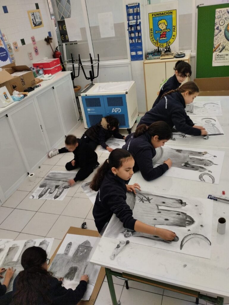 Niños participando en un taller de dibujo artístico con carboncillo
