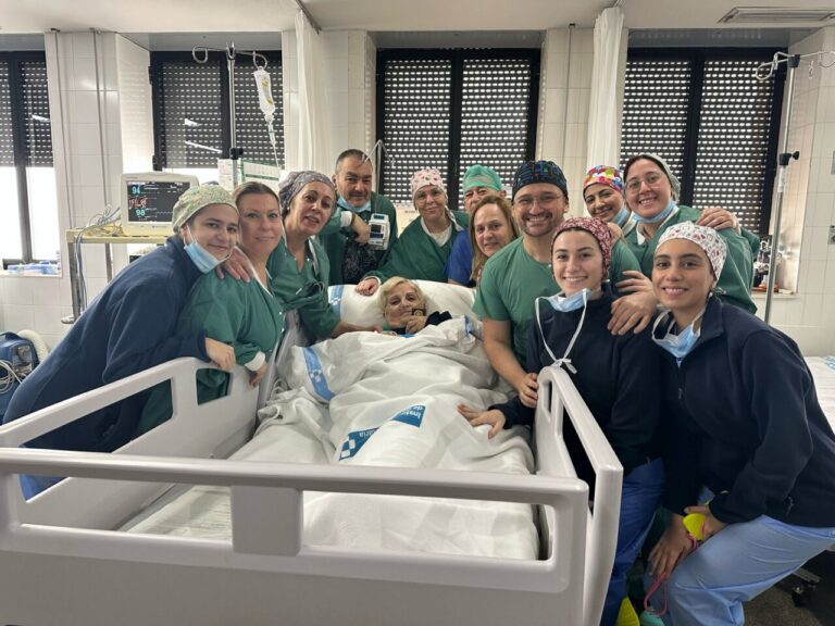 Grupo de médicos y enfermeras con paciente en hospital tras cirugía