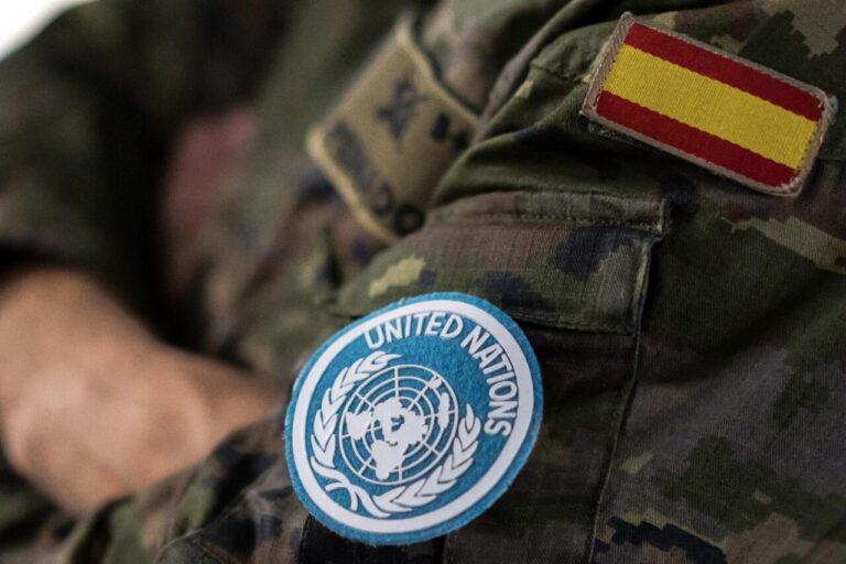 Militar español con insignia de la ONU y bandera de España en uniforme