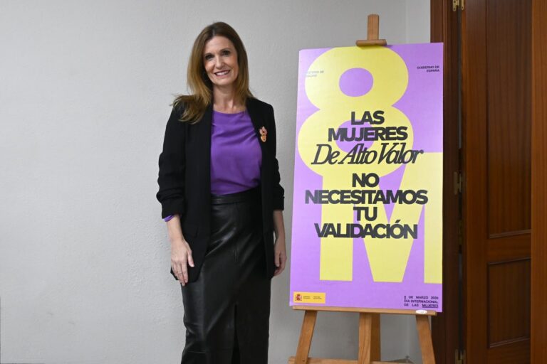Mujer sonriente junto a un cartel sobre el Día Internacional de las Mujeres