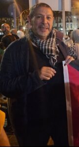Mustafa Aberchán sosteniendo una bandera en un evento público