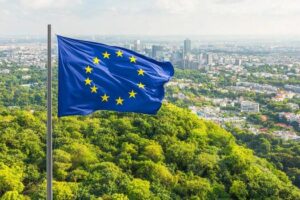 Bandera de la Unión Europea ondeando sobre un paisaje urbano