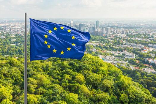 Bandera de la Unión Europea ondeando sobre un paisaje urbano