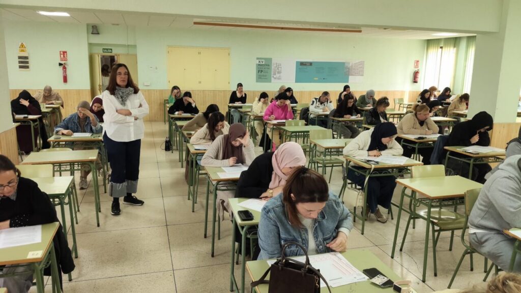 Estudiantes realizando exámenes en un aula durante oposiciones de sanidad pública en Melilla.