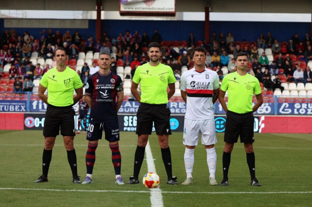 Jugadores y árbitros alineados antes del partido entre Extremadura y Melilla