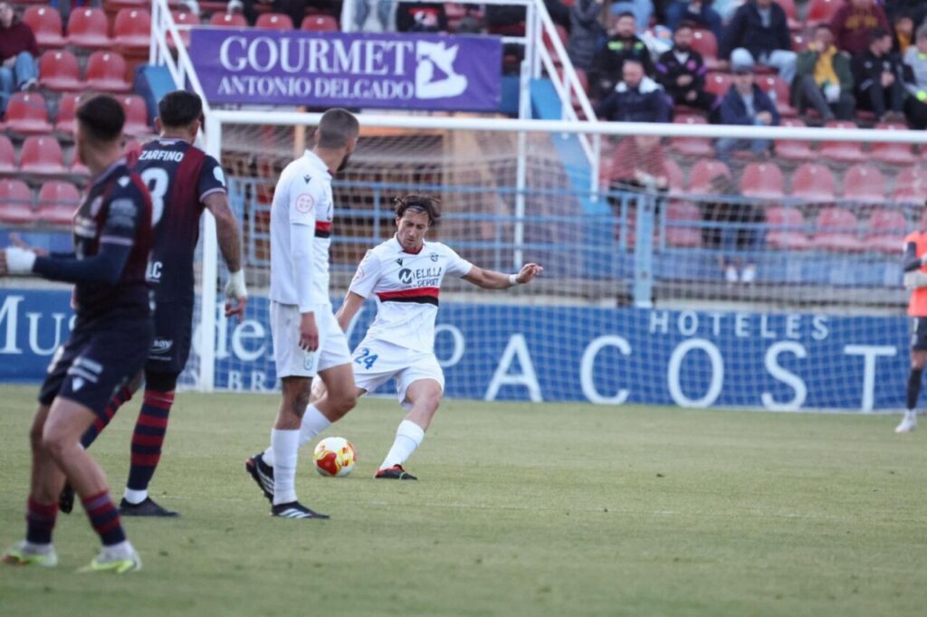 Jugadores de fútbol en un partido entre Melilla y Extremadura