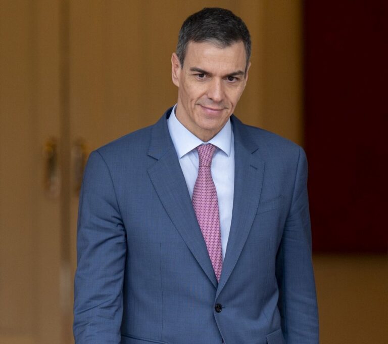 Pedro Sánchez en un evento oficial, vestido con traje y corbata.