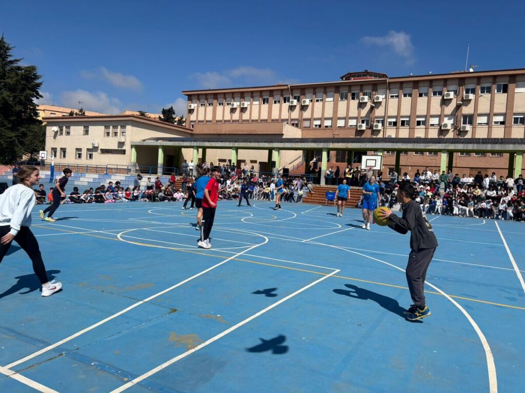 Jugadores de baloncesto interactuando con alumnos en el colegio