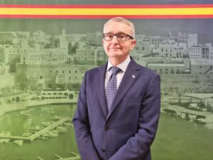 Persona en traje frente a un fondo histórico de Melilla