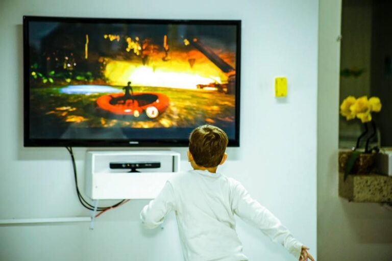 Niño jugando frente a un televisor con un videojuego