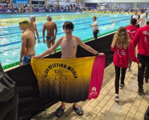 Rubén Román con bandera del Club Atlético Melilla en campeonato de natación