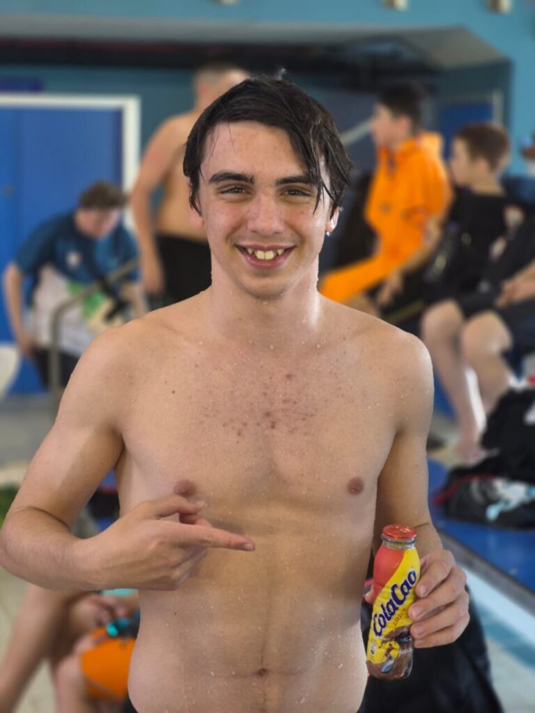 Joven nadador Rubén Román Muñoz mostrando su medalla y bebida