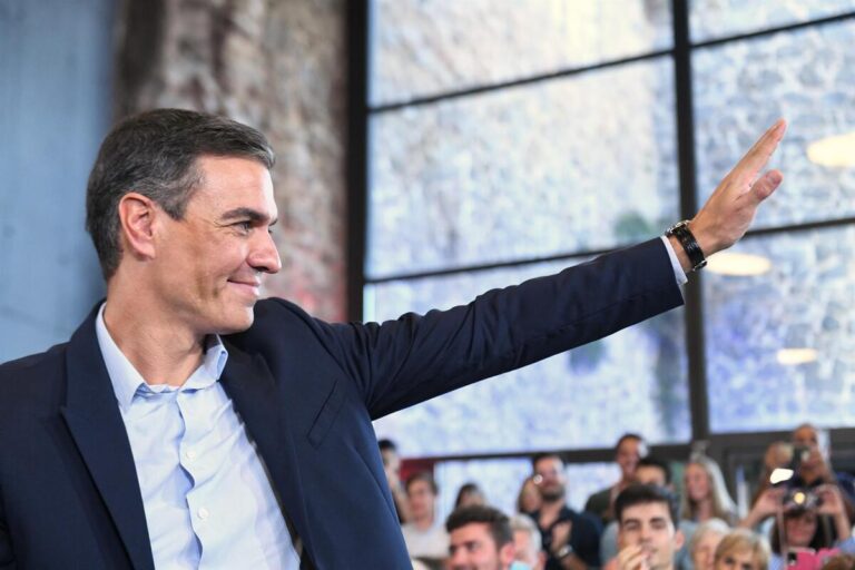 Pedro Sánchez durante un evento político levantando la mano en señal de apoyo