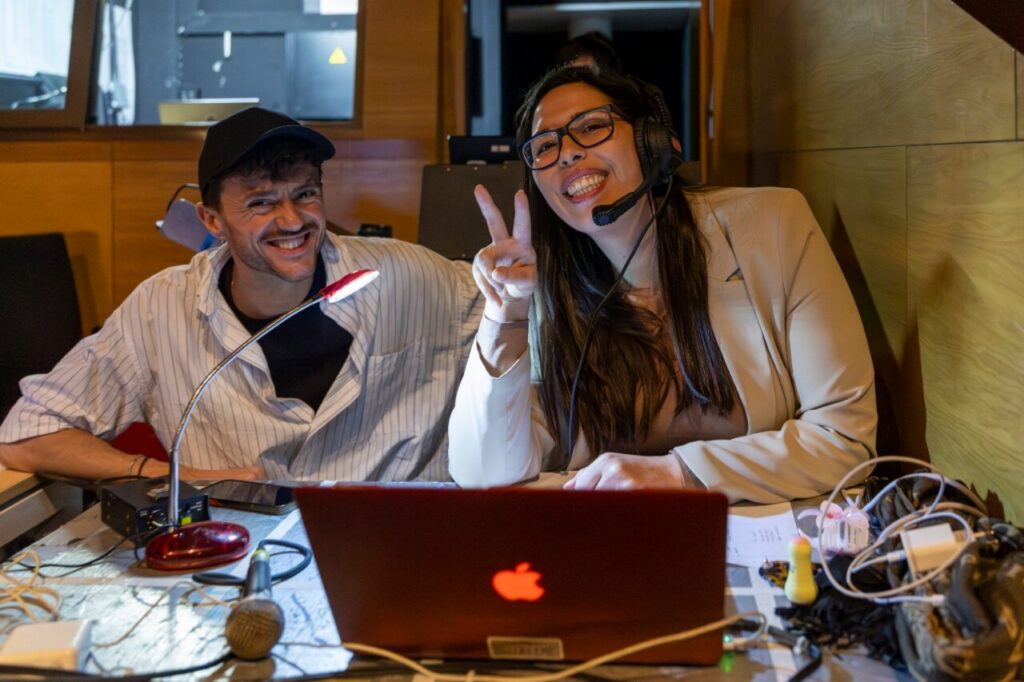 Dos personas sonrientes en el backstage del teatro durante la obra Hamlet.