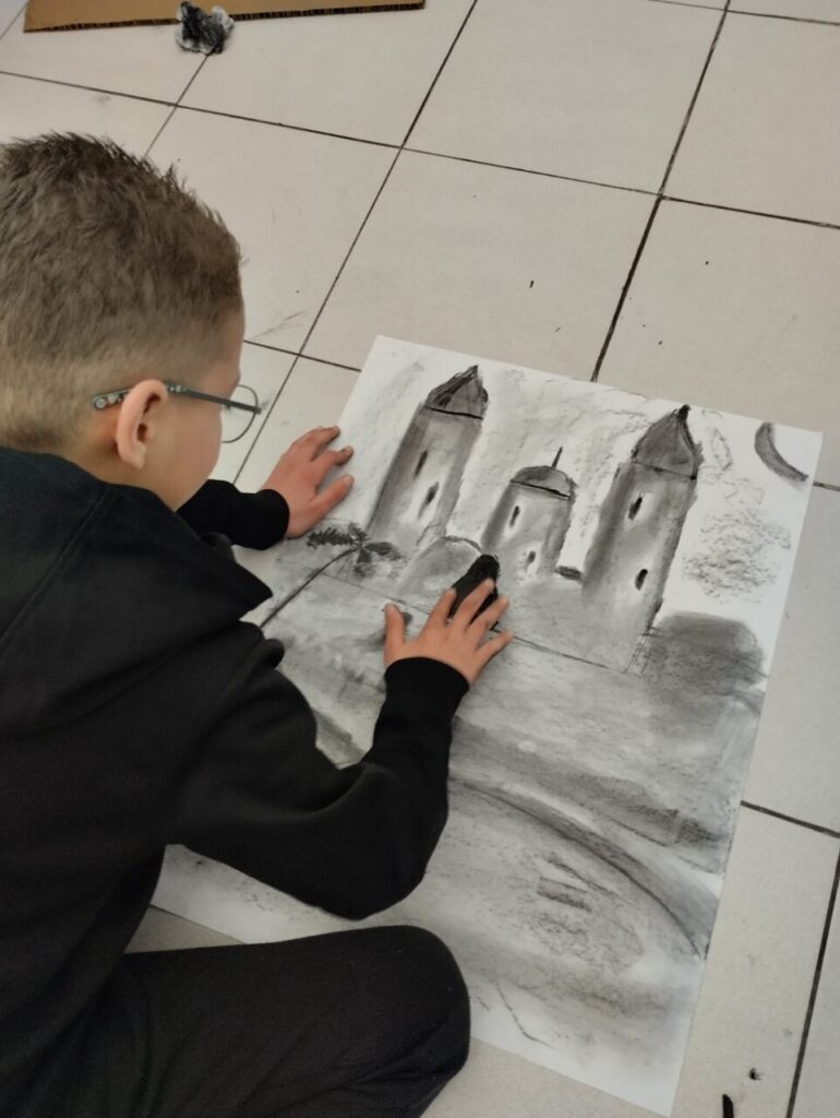 Niño dibujando con carboncillo en un taller artístico