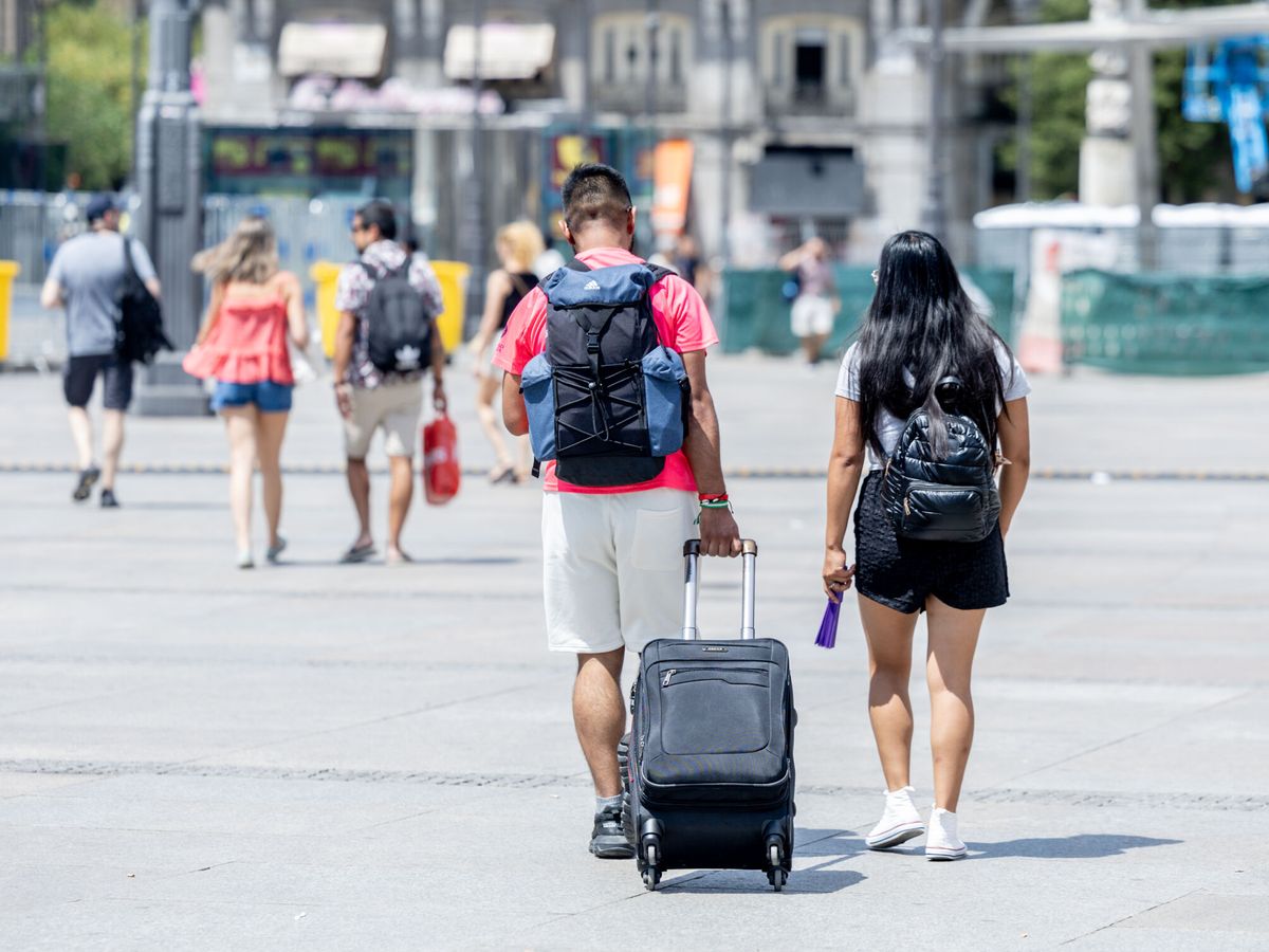 Pareja de turistas caminando en Madrid con maleta