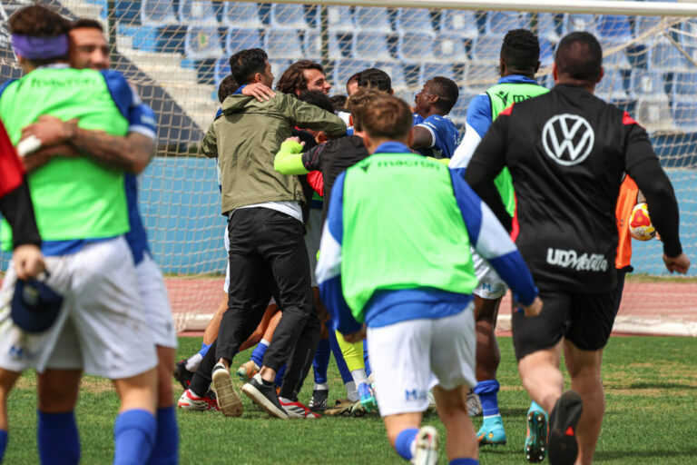 Jugadores de la U.D. Melilla celebrando un gol en el campo.